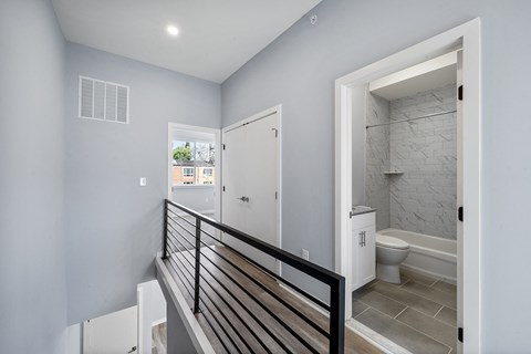 A bathroom with a toilet, sink, and a window.