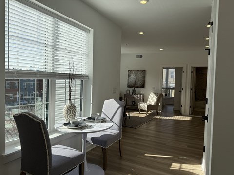 A dining room with a table set for two and a view of the city.