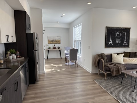 A modern kitchen with dark wood cabinets and a black refrigerator.