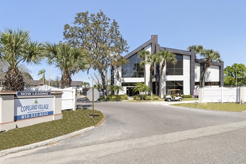 A modern house with a white fence and a sign that says "Copeland Village".