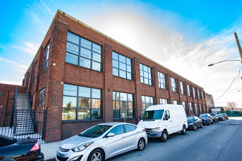 A row of cars parked in front of a red brick building.