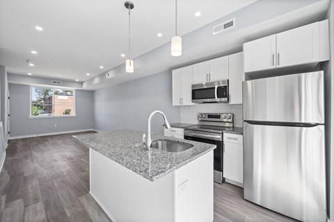 A modern kitchen with a granite countertop and stainless steel appliances.