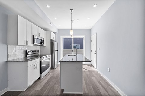 A modern kitchen with white cabinets and a large island.