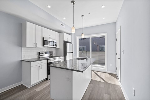A modern kitchen with white cabinets and a central island.