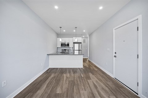 A spacious kitchen with a white countertop and wooden flooring.