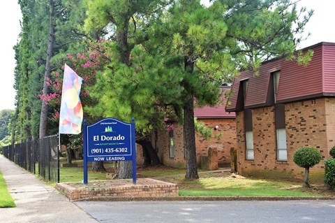 A sign for El Dorado is in front of a brick building.