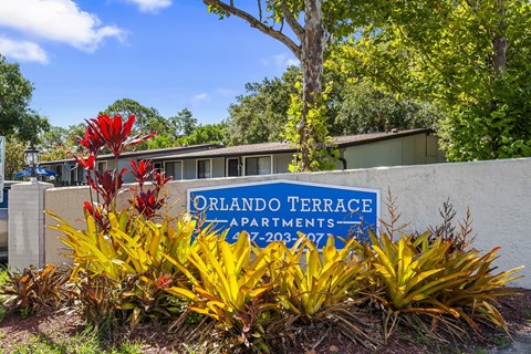 A sign for Orlando Terrace Apartments stands in front of a building.