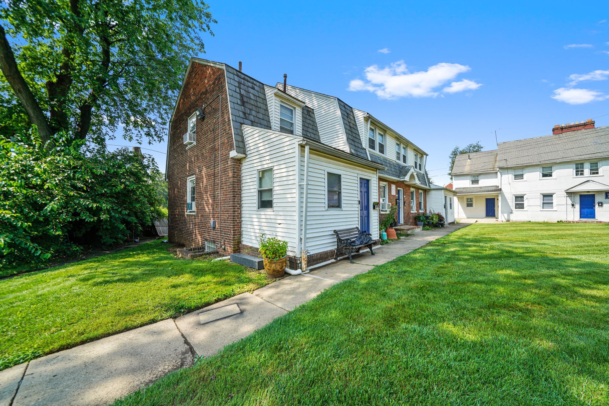 the front of a house with a lawn and a sidewalk