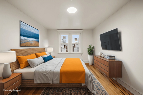 A bedroom with a bed, a nightstand, a lamp, a plant, and a painting on the wall.