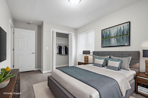 A bedroom with a bed, nightstands, and a painting on the wall.