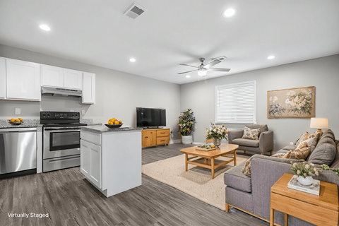 A modern kitchen with a dining area and a living room.