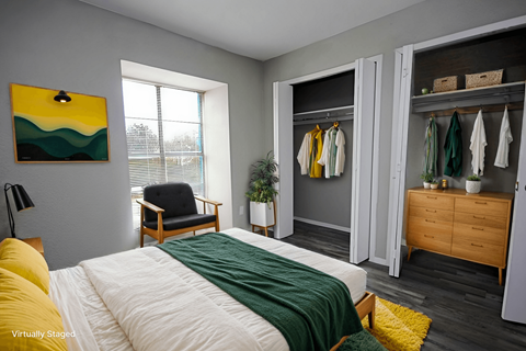 A bedroom with a bed, chair, and wardrobe.