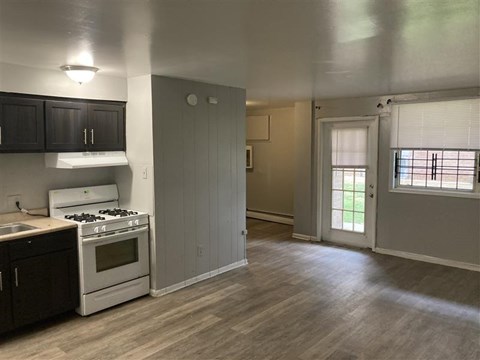 A kitchen with a white stove and black cabinets.