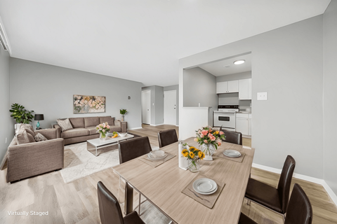 A modern dining room with a wooden table set for two.