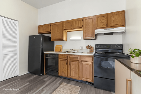 A kitchen with black appliances and wooden cabinets.