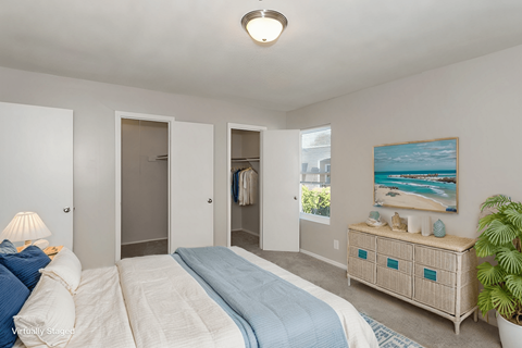 A bedroom with a bed, nightstand, and a painting on the wall.