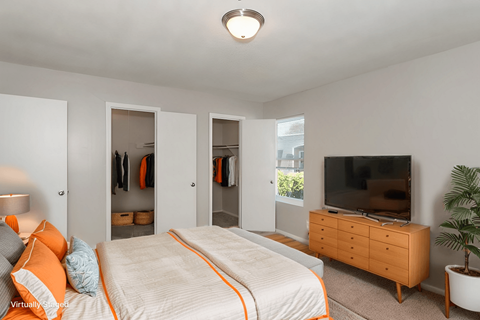 A bedroom with a bed, dresser, and mirror.