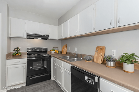 A kitchen with white cabinets and a black oven.