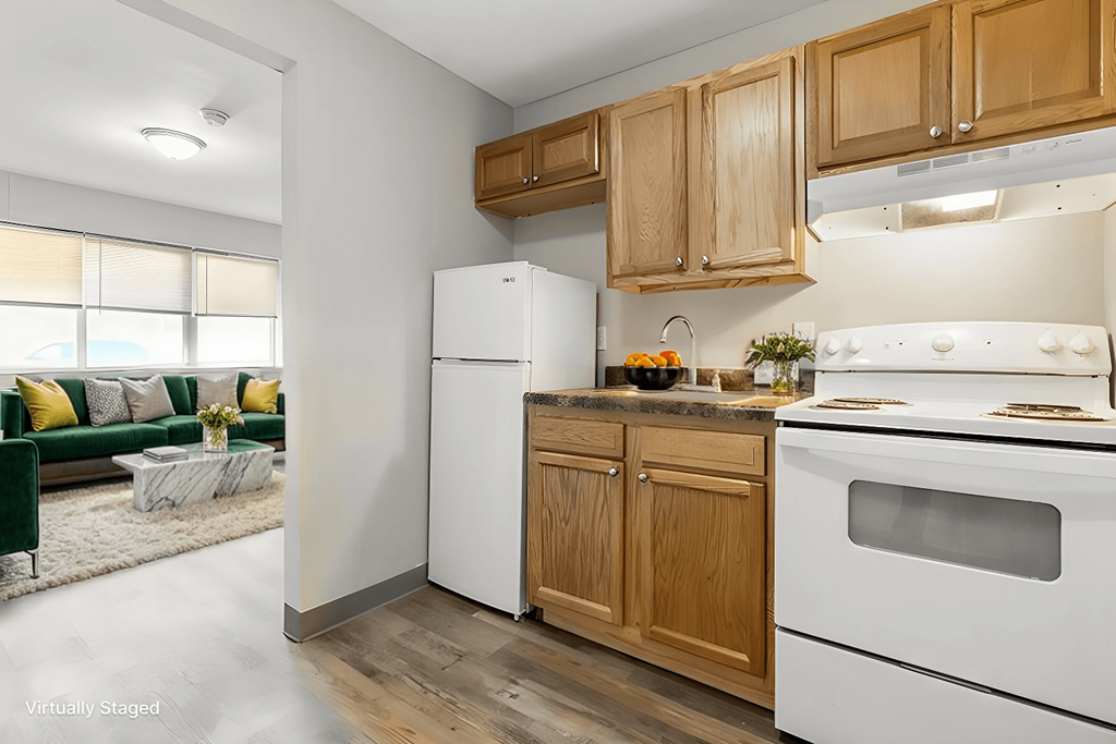 A kitchen with a white refrigerator and white stove with wooden cabinets.