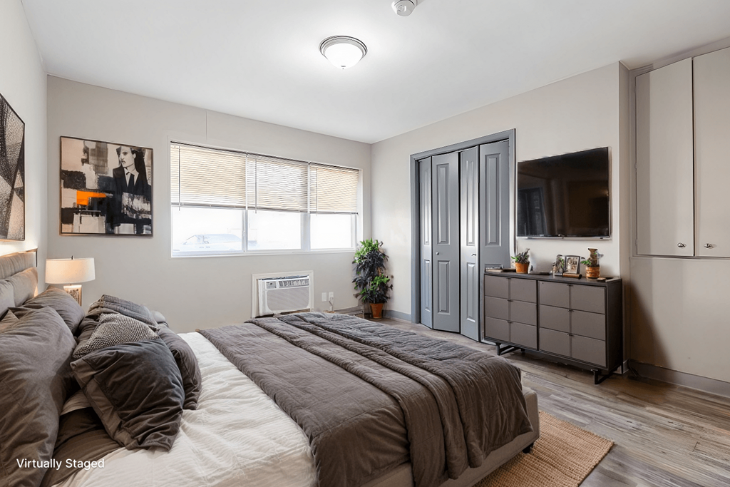 A bedroom with a large bed and a dresser.