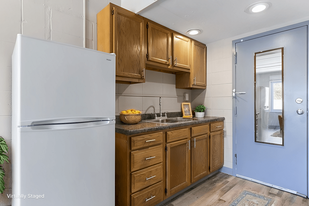 A kitchen with a white fridge and wooden cabinets.