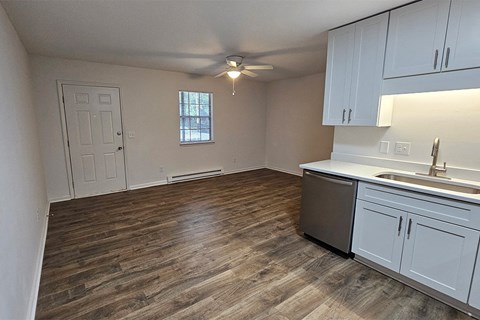 an empty kitchen and living room with a ceiling fan
