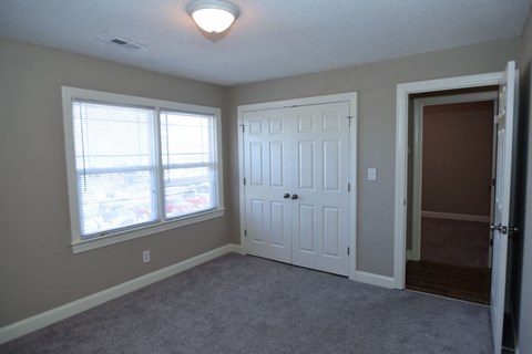 a bedroom with a door and a window and a closet