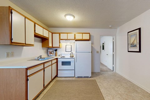 a kitchen with white appliances and wooden cabinets