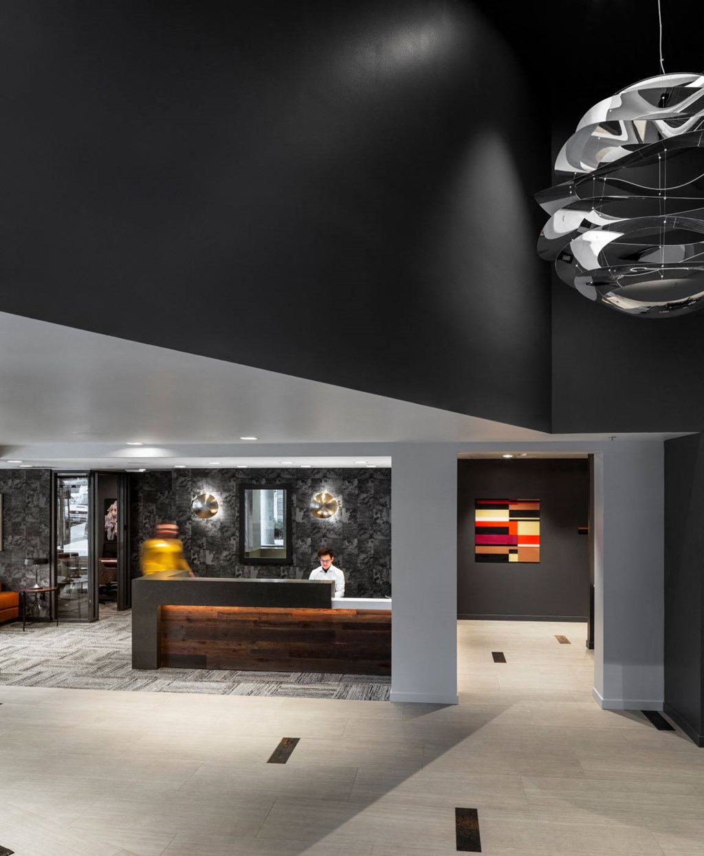 the lobby of a hotel with a reception desk and lights