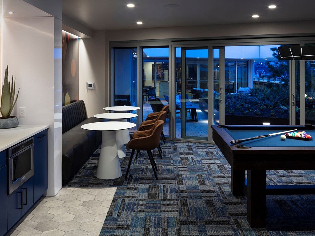 a living room with a pool table and a bar