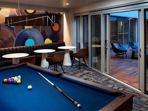 a games room with a pool table and tables