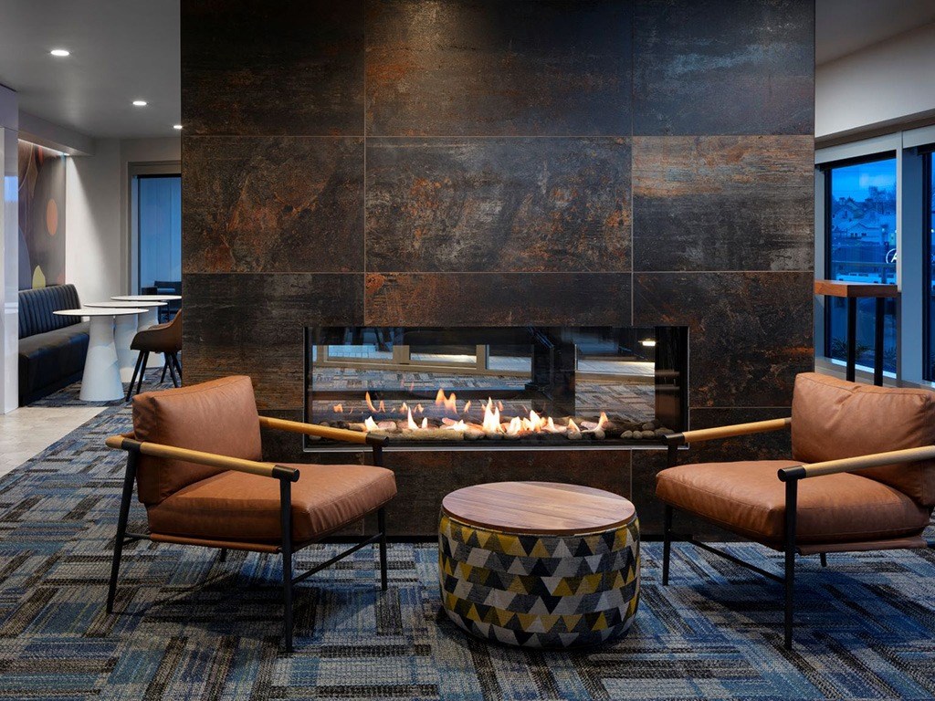 a living room with a fireplace and chairs and a table