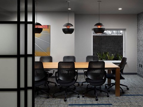 a conference room with a wooden table and black chairs