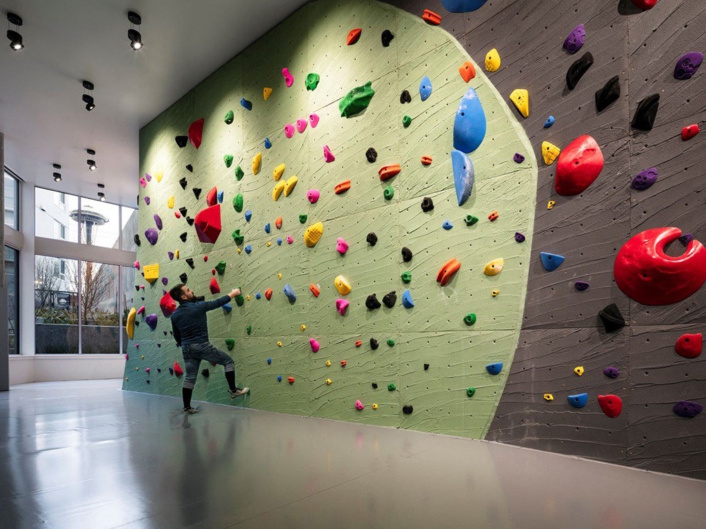 a man climbing up a rock climbing wall