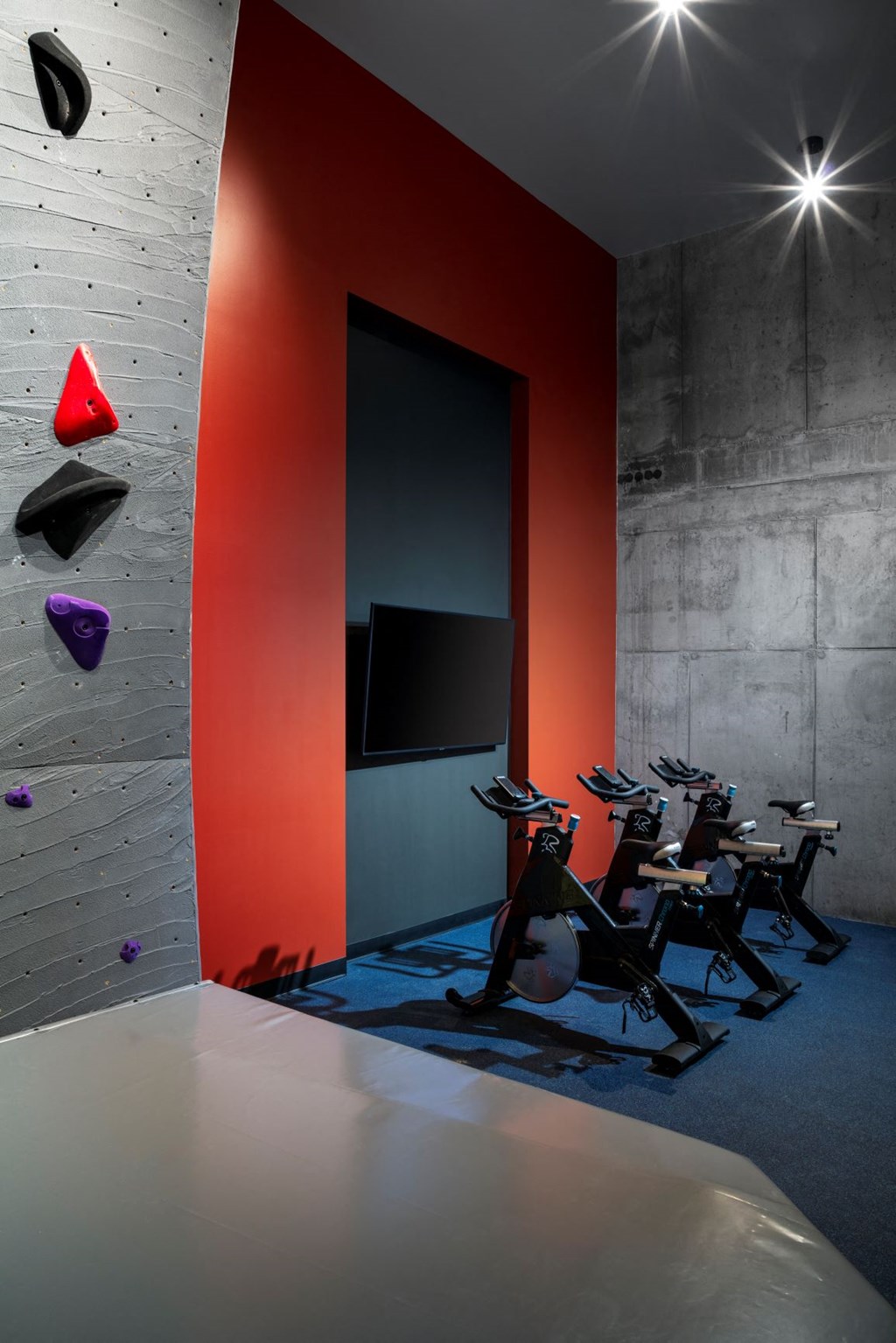 a gym with red and white walls and chairs and a television
