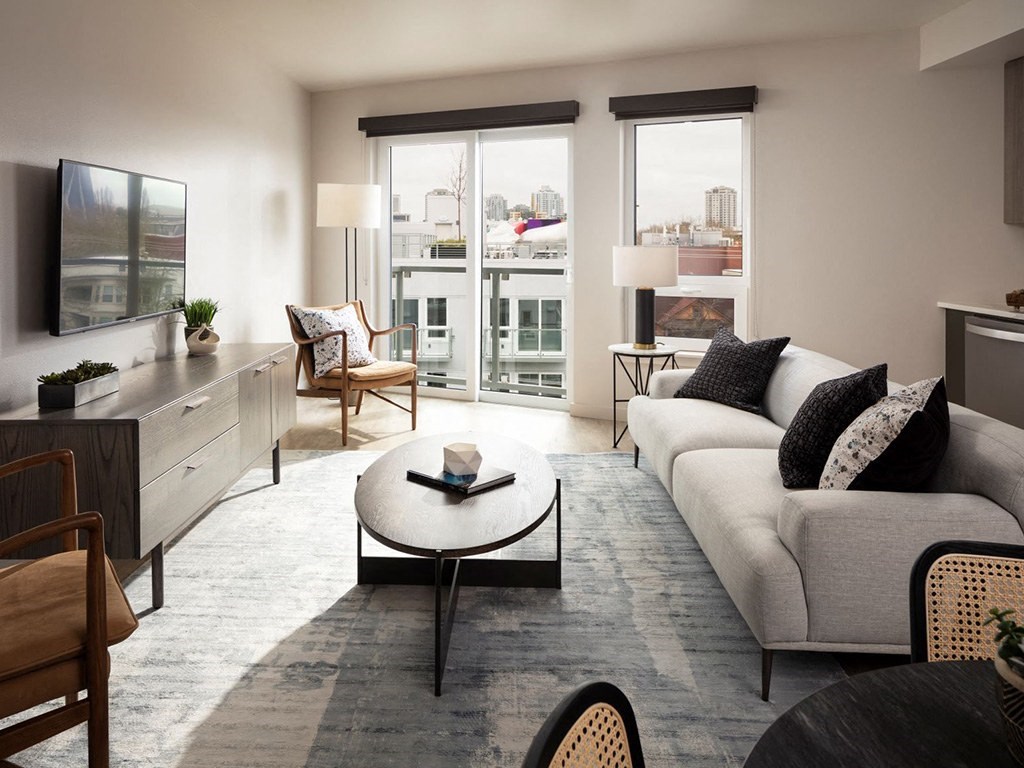a living room with a couch and a coffee table    and a balcony