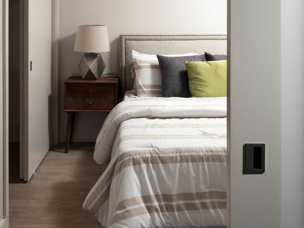 a bedroom with a bed and a nightstand with a lamp