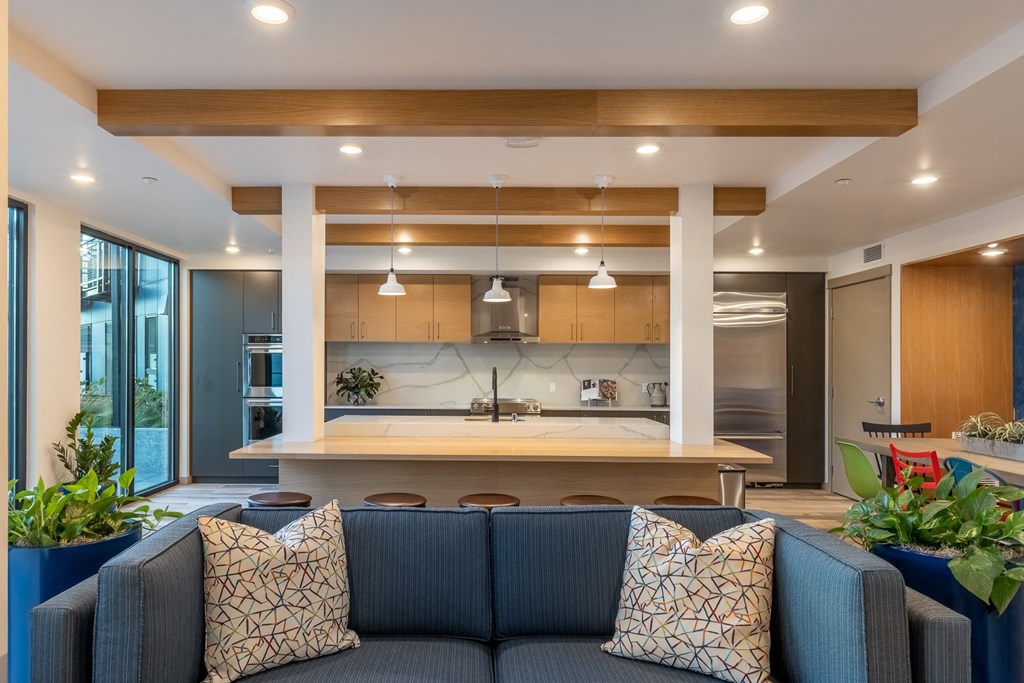 the kitchen and living room of a modern house with a blue couch