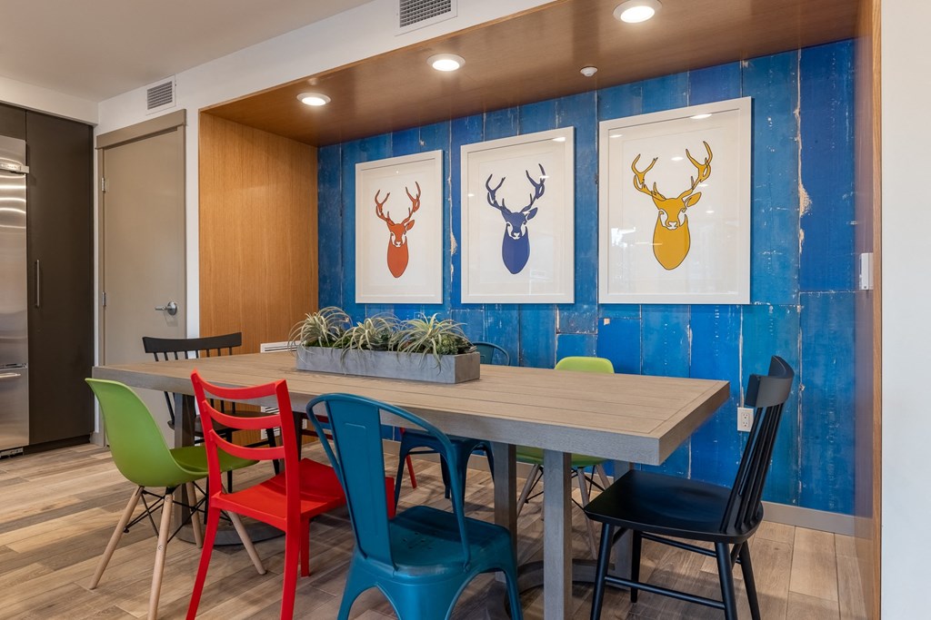 a dining room with a table and colorful chairs