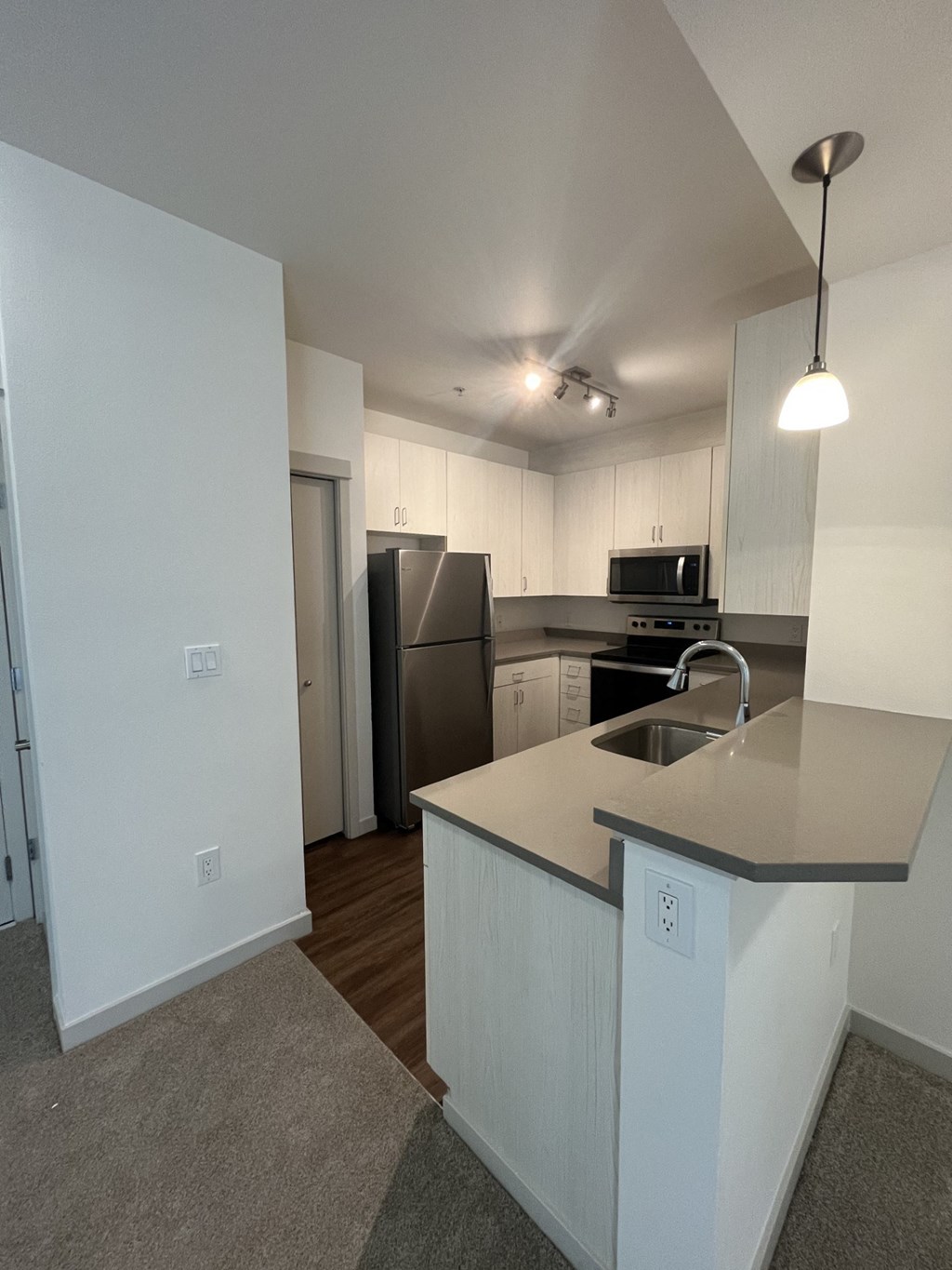 a kitchen with an island and a stainless steel refrigerator