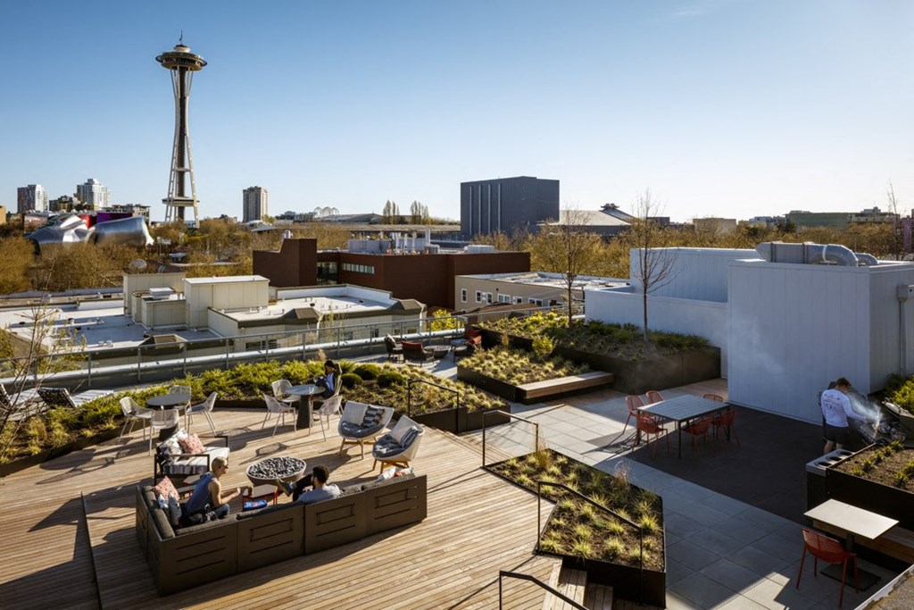 a roof terrace with tables and chairs and a view of the city