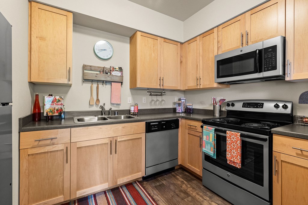 a kitchen with wooden cabinets and stainless steel appliances and a microwave