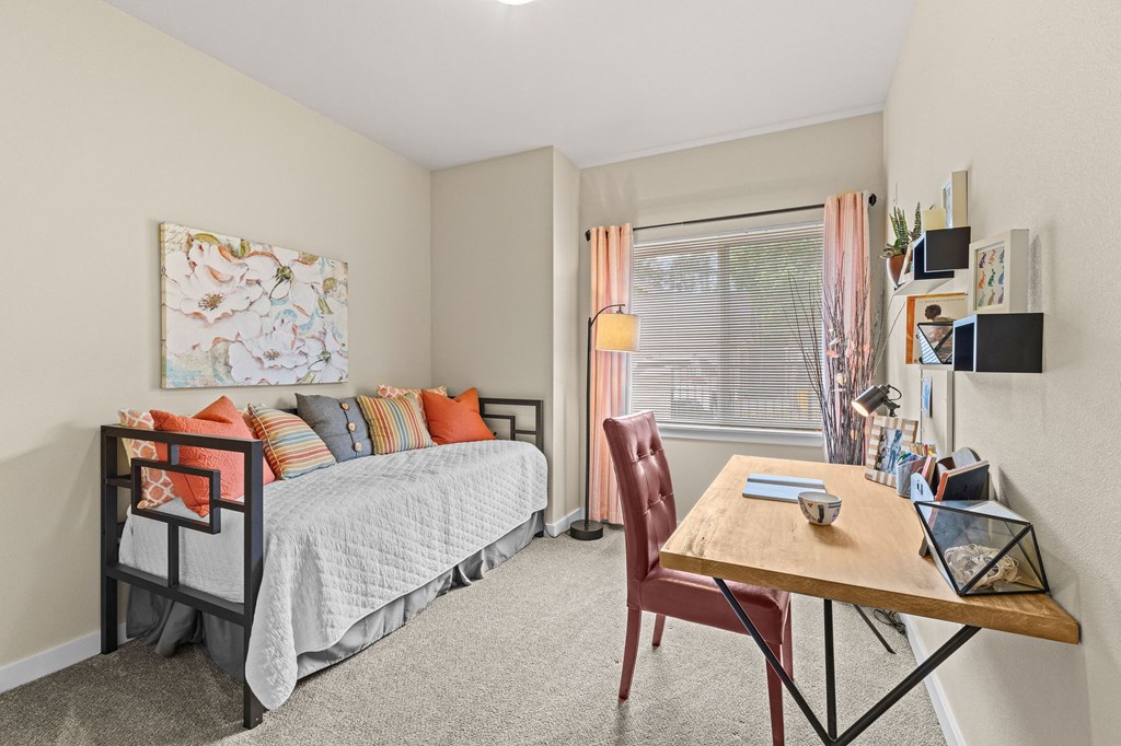 a bedroom with a bed and a desk and a window