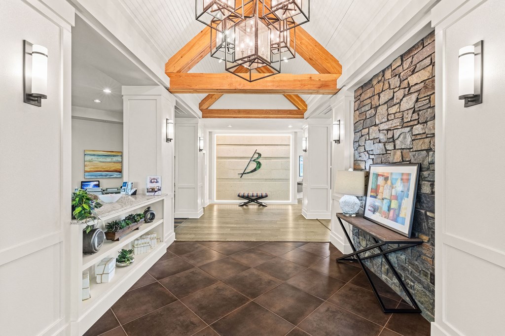 a long hallway with a stone wall and a vaulted ceiling with a light fixture