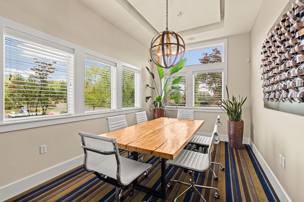 a dining room with a table and chairs and windows
