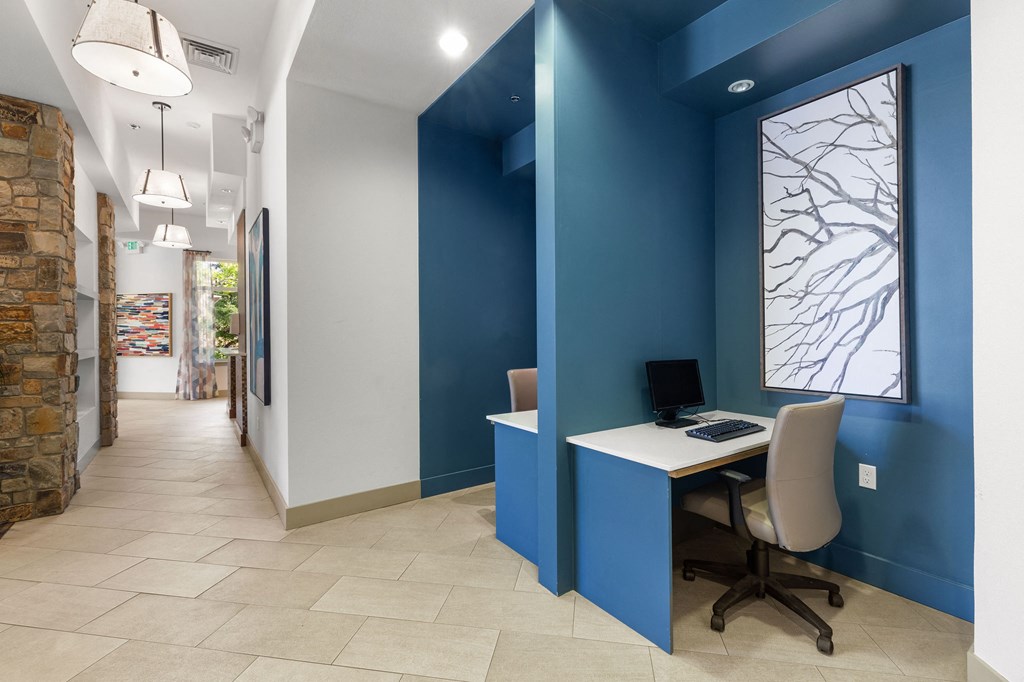 a home office with a desk and a computer in a hallway