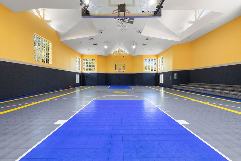 a large gym with a blue floor and a scoreboard