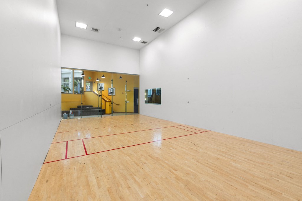 a basketball court in the center of a white room with wood floors and a yellow