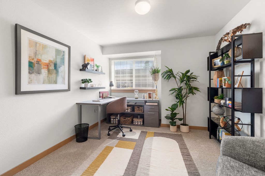 an office with a desk and a window and a plant