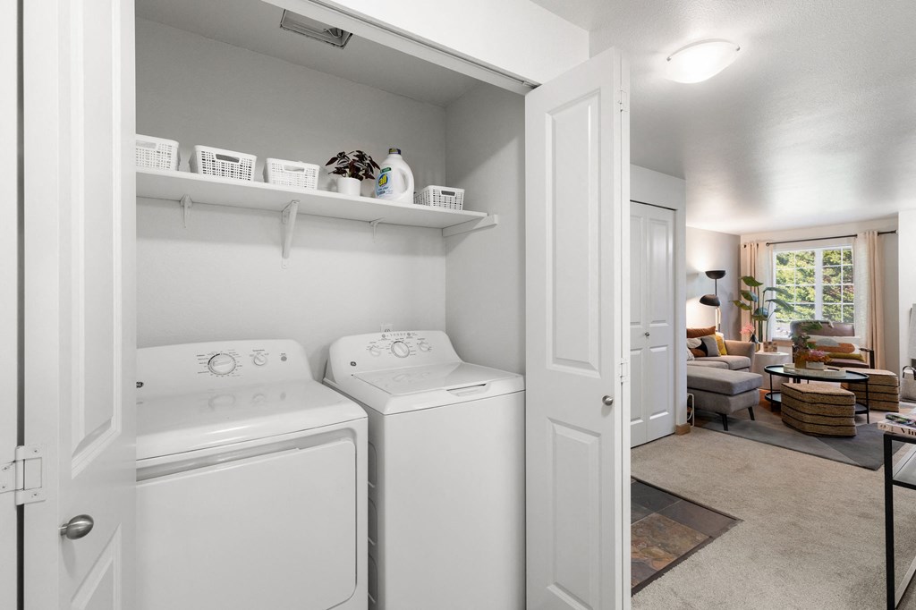 a white laundry room with two washes and a dryer